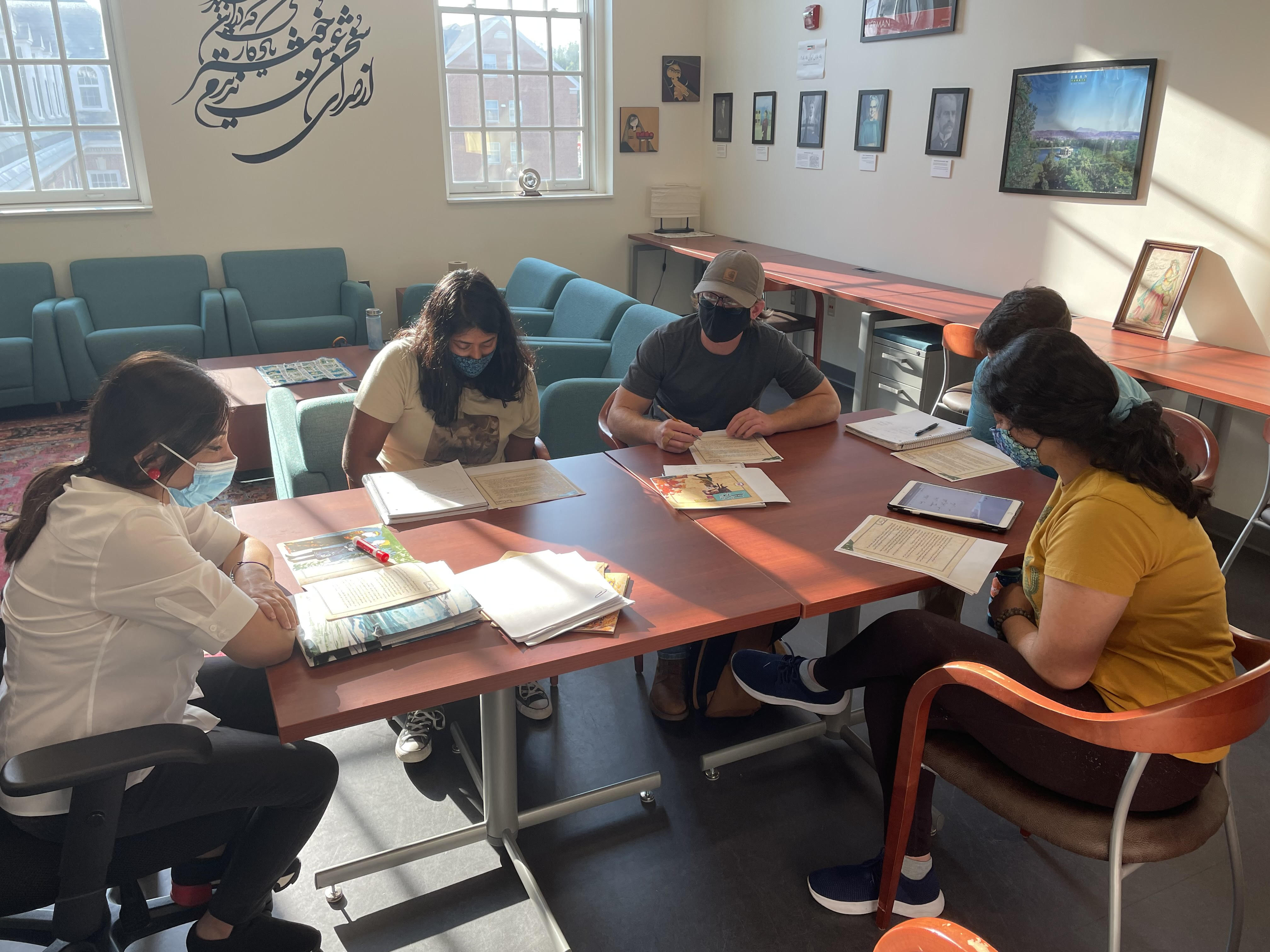 A group of Persian Flagship students sit at a table during their shahnameh club